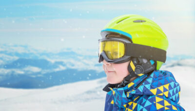 Child wearing a ski helmet and goggles in the snow